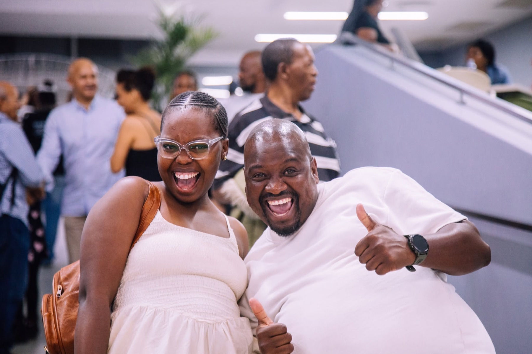 Two church members laughing with thumbs up in the foyer